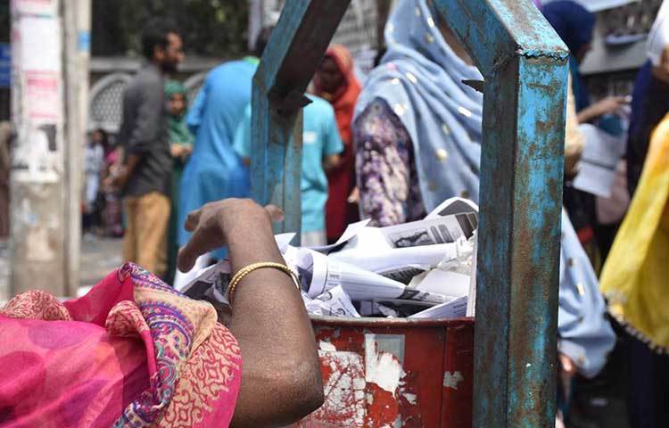 বিভিন্ন স্থানে পড়ে থাকা ডাকসু নির্বাচনী প্রচারপত্র ডাস্টবিনে ফেলছেন এক পরিচ্ছন্নতাকর্মী। ছবি: বিপ্লব দিক্ষিৎ