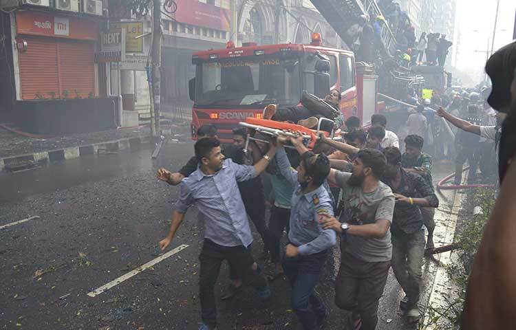 আগুনের হাত থেকে উদ্ধার করা একজনকে নিয়ে যাচ্ছে স্কাউটের সদস্যরা। ছবি: বিপ্লব দিক্ষিৎ