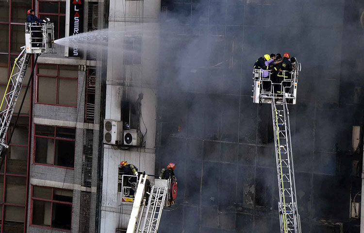 ভবনে আটকে পড়াদের নামানোর চেষ্টা। ছবি: বিপ্লব দিক্ষিৎ