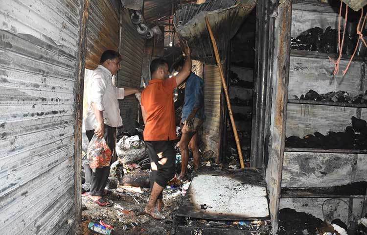আগুনে পোড়া দোকানের মাঝে হয়তো তারা আবারও জীবনের স্বপ্ন খুঁজছেন। ছবি: বিপ্লব দিক্ষিৎ