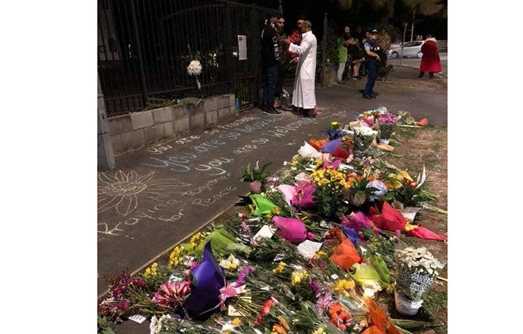 ক্রাইস্টচার্চের আল নুর মসজিদের বাইরে ফুল দিয়ে নিহতদের স্মরণ করছেন সে দেশের মানুষ।