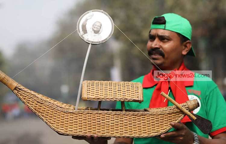 বেতের নৌকার উপর প্রিয় নেত্রীর ছবি নিয়ে আওয়ামী লীগের এক অনুরাগী। ছবি : বিপ্লব দিক্ষিৎ