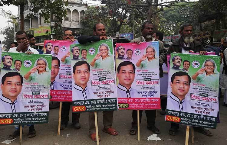গাজীপুর সিটি কর্পোরেশনের মেয়র আলহাজ্ব এড. মোঃ জাহাঙ্গীর আলমের সমর্থকরা প্লাকার্ড নিয়ে সমাবেশে এসেছে। ছবি : মাহবুব আলম