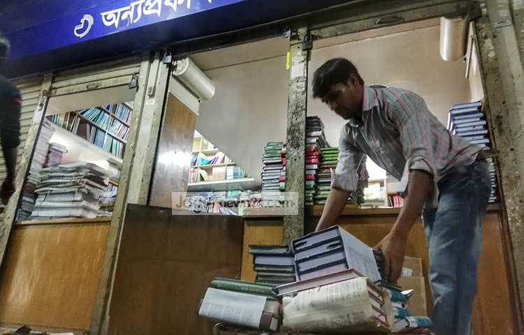 টুকরিতে করে বই নিয়ে যাওয়া হচ্ছে। ছবি : মাহবুব আলম
