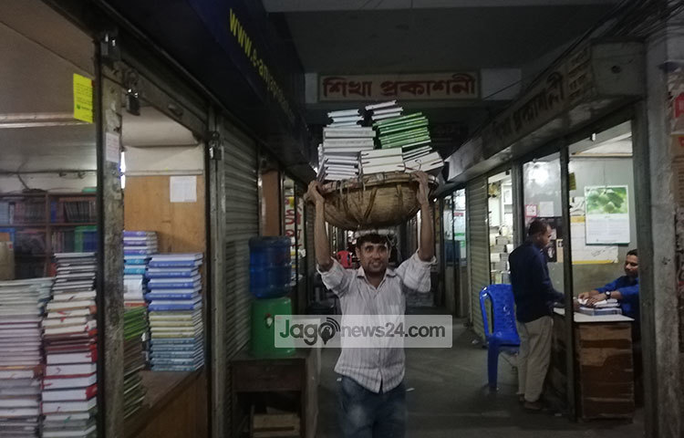 বই নিয়ে নির্দিষ্ট গন্তব্যে যাচ্ছে এক শ্রমিক। ছবি : মাহবুব আলম