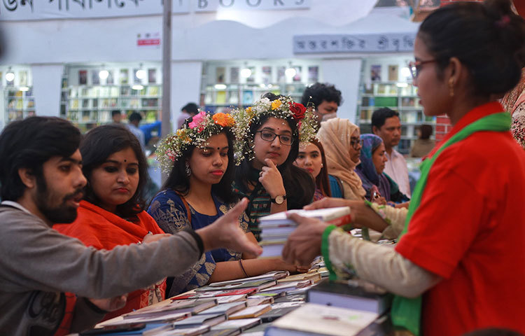 একগুচ্ছ প্রিয় বই কিনছেন এক পাঠক। বইয়ের টানেই বইমেলায় ছুটে আসছেন পাঠকরা। ছবি: মাহবুব আলম