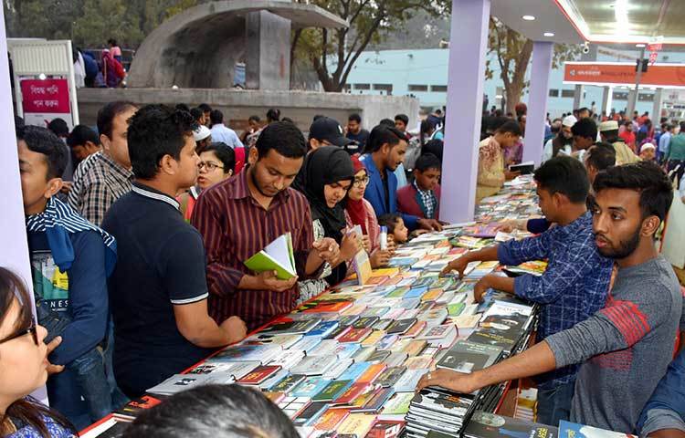 আপন মনে বই খুলে দেখছেন পাঠকরা। ছবি: বিপ্লব দিক্ষিৎ