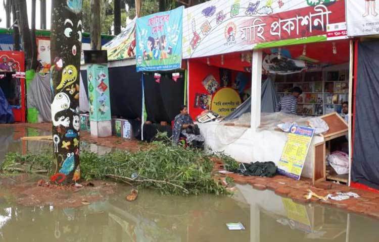 দমকা হাওয়ায় একটি স্টলের সামনে গাছের ঢাল ভেঙে পড়েছে, এতে ক্ষতিগ্রস্ত হয়েছে স্টলটি।