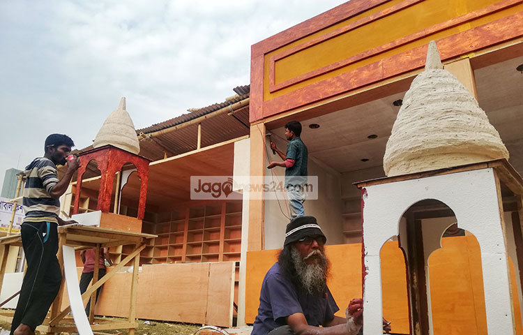 স্টলের সৌন্দর্য বর্ধনে রঙ করার কাজে ব্যস্ত এক শিল্পী। ছবি : মাহবুব আলম