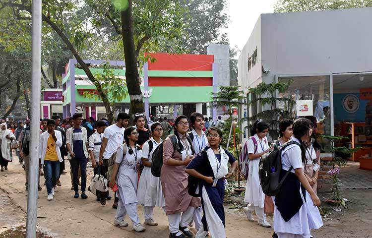 স্কুলের শিক্ষার্থীরা বইমেলায় বই কিনতে এসেছে। ছবি: বিপ্লব দিক্ষিৎ