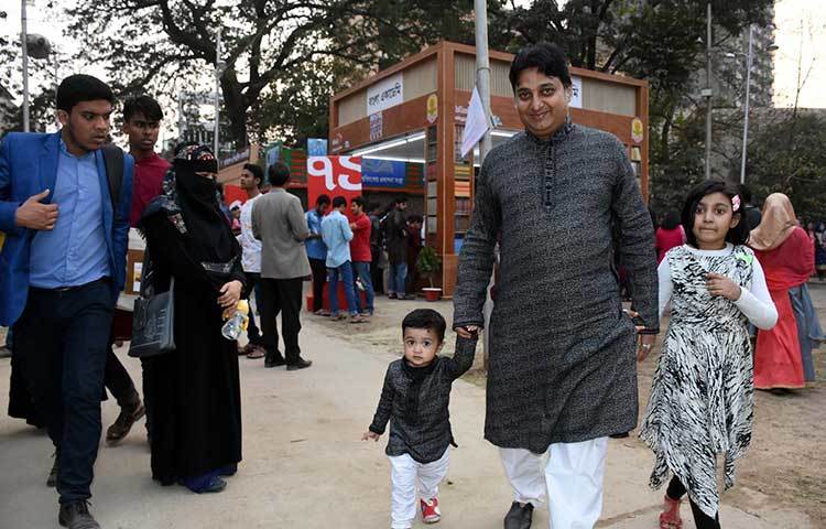 দুই শিশুসন্তানকে নিয়ে বইমেলায় এসেছেন এক বইপ্রেমী। ছবি : বিপ্লব দিক্ষিৎ