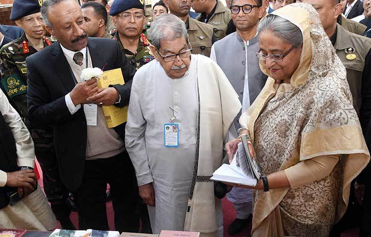 নিজেকে নিয়ে লেখা একটি বই খুলে দেখছেন প্রধানমন্ত্রী।