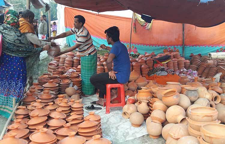 দূরদূরান্ত থেকে আসা মানুষজন মাটির জিনিসপত্র বিক্রি হচ্ছে। ছবি : আবদুর রহমান আরমান