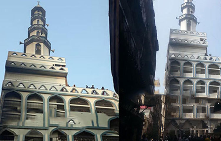 আগুনের হাত থেকে রক্ষা পাওয়া মসজিদটি দাঁড়িয়ে আছে।