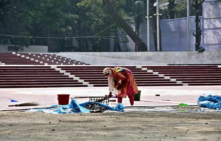 কেন্দ্রীয় শহীদ মিনার এলাকার ময়লা-আবর্জনা সারিয়ে নিচ্ছেন এক পরিচ্ছন্নতা কর্মী। ছবি: বিপ্লব দিক্ষিৎ