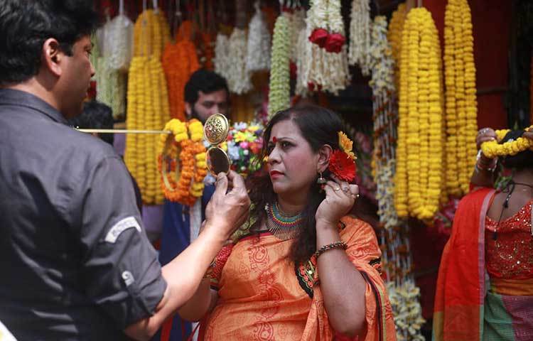 চুলে ফুল দিয়ে সাজছেন এক নারী। বাসন্তী সাজে আজ চারদিক মাতোয়ারা। ছবি: মাহবুব আলম