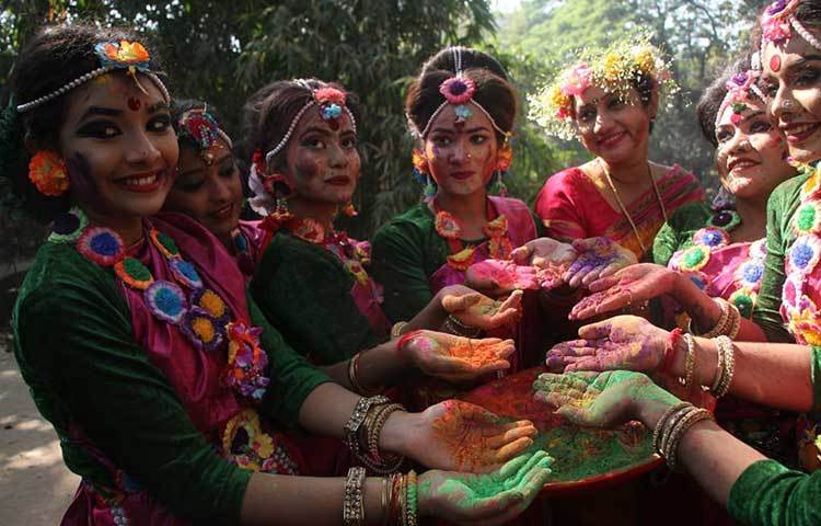 রঙ মেখে বসন্তকে বরণ করছেন তরুণীরা। ছবি: মাহবুব আলম