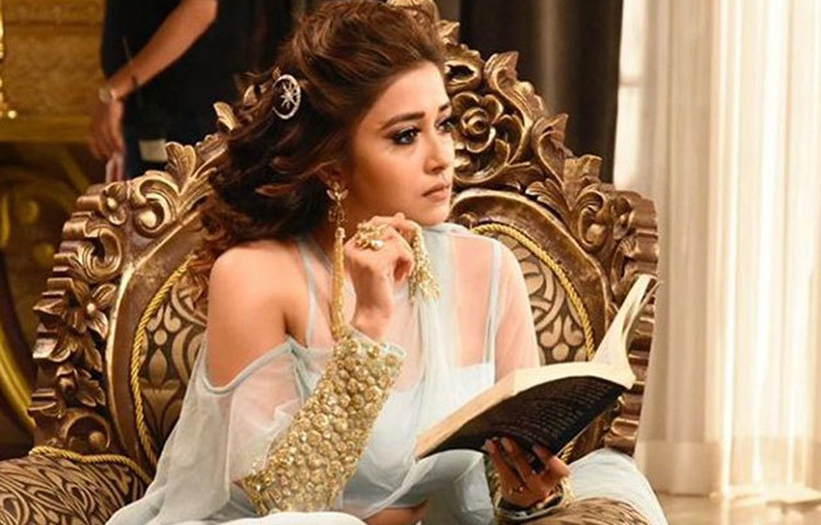 বই হাতে কাজের ফাঁকে টিনা। বিভিন্ন দেশের খ্যাতনামা লেখকদের বই রয়েছে তার কাছে।