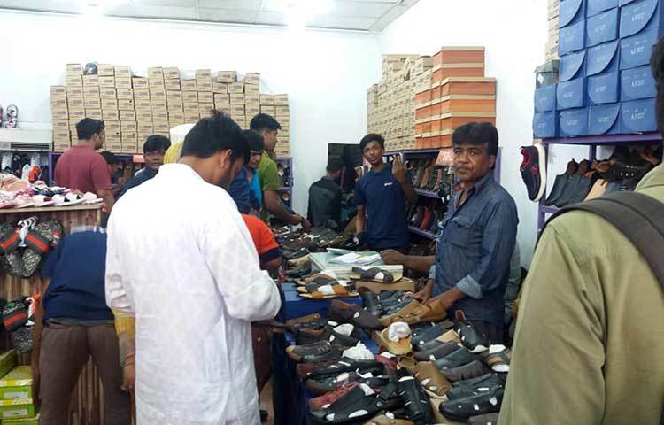 ক্রেতারা জুতোর দোকানে পছন্দের জুতো কিনছেন। ছবি : প্রদীপ দাস
