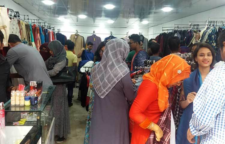 পোশাকের স্টলে ক্রেতাদের ভিড়। প্রতিবারের মত এবারের মেলার শেষ দিকেও বিভিন্ন স্টলে পণ্যের মূল্যে বিশাল ছাড় দেয়া হয়েছে। ছবি : প্রদীপ দাস