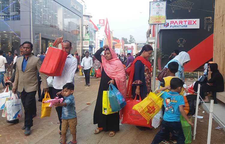 শিশুসন্তানদের দিয়ে বাণিজ্য মেলায় এসেছেন বাবা-মায়েরা। ছবি : প্রদীপ দাস