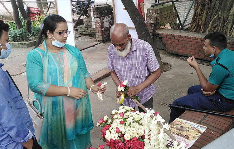 ফুলের মালা কিনছেন একজন। ছবি: মাসুমা মুসরাত শৈলী