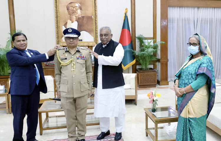 প্রধানমন্ত্রী শেখ হাসিনার উপস্থিতিতে পুলিশের নবনিযুক্ত মহাপরিদর্শক (আইজিপি) চৌধুরী আবদুল্লাহ আল-মামুনকে র্যাংঙ্ক ব্যাজ পরিয়ে দেন স্বরাষ্ট্রমন্ত্রী আসাদুজ্জামান খান ও স্বরাষ্ট্র মন্ত্রণালয়ের জননিরাপত্তা বিভাগের সিনিয়র সচিব মো. আখতার হোসেন। ছবি: পিআইডি