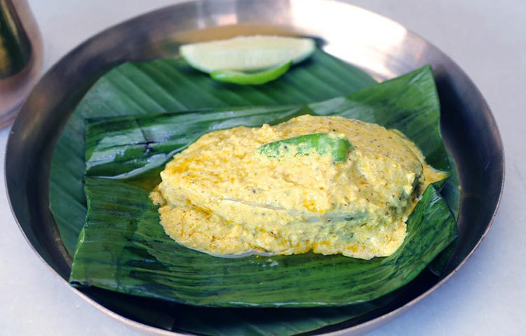 সরষে বাটা ও নারকেল দিয়ে কলাপাতায় ভাপা ইলিশ।