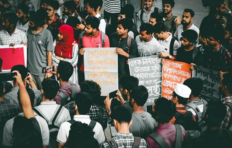 জগন্নাথ বিশ্ববিদ্যালয়ের দ্বিতীয় ক্যাম্পাসের নির্মাণ কাজ দ্রুত বাস্তবায়ন ও কাজে কেরানীগঞ্জ উপজেলা চেয়ারম্যান শাহীন আহমেদ হস্তক্ষেপ করায় তাকে দ্রুত গ্রেফতারসহ ১০ দফা দাবিতে মানববন্ধন ও দফায় দফায় বিক্ষোভ মিছিল করেছেন শিক্ষার্থীরা। ছবি: জাগো নিউজ