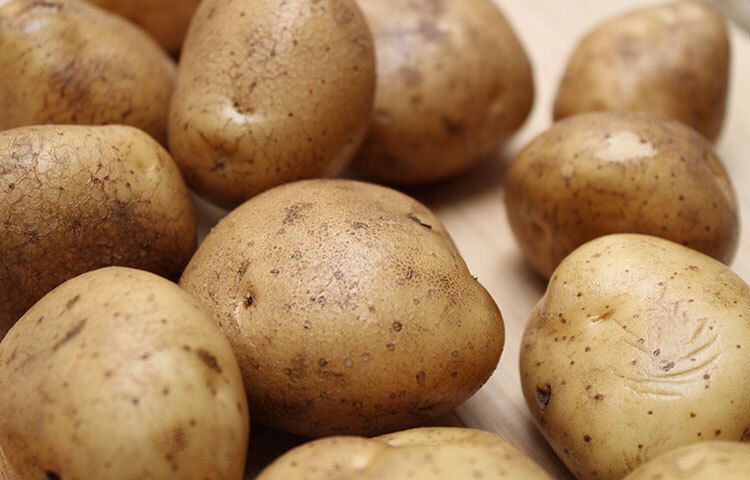 আলু টুকরো করে কেটে নিন। একটি টুকরো হালকা করে ঘষতে থাকুন। আলুর রস ভালো করে আঁচিলে লাগছে কী না দেখুন। ছবি: সংগৃহীত