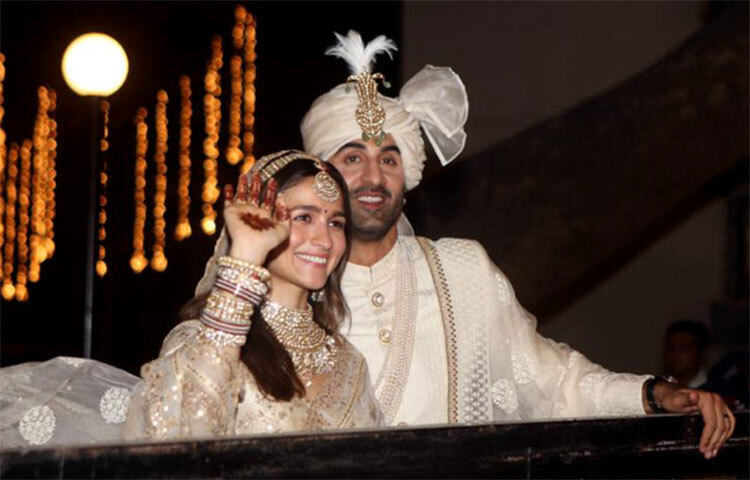 বান্দ্রার ‘বাস্তু’ বহুতলের বাইরে ভক্তদের ডাকে সাড়া দিয়ে নবদম্পতি বাইরে বেরিয়ে হাত নাড়তেই ঝলসে উঠেছে ফটো শিকারীদের ক্যামেরা। ছবি: সংগৃহীত