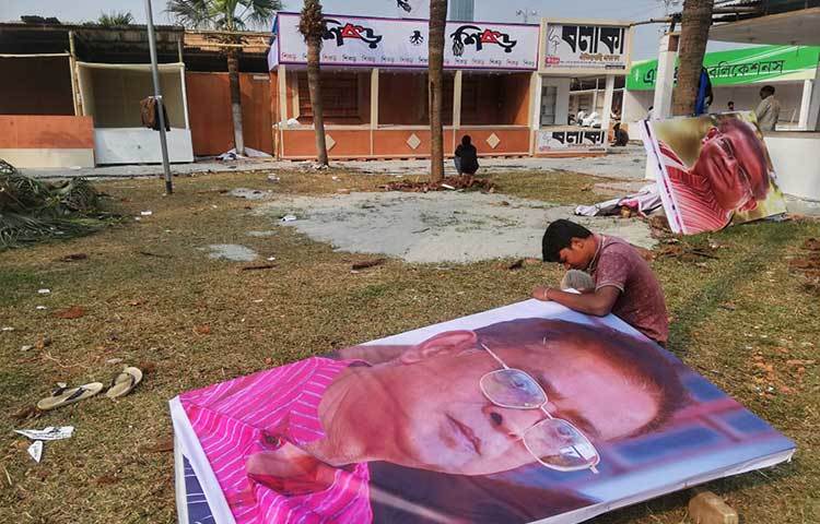 বাংলাদেশের সবচেয়ে জনপ্রিয় কথাসাহিত্যিক হুমায়ূন আহমেদের ছবি দিয়ে স্টল সাজানোর জন্য ছবি বাঁধাই করা হচ্ছে। ছবি: মাহবুব আলম