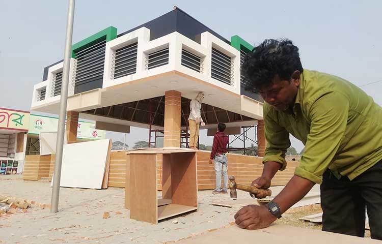 স্টল সাজাতে ব্যস্ত এক কর্মী। ছবি: মাহবুব আলম
