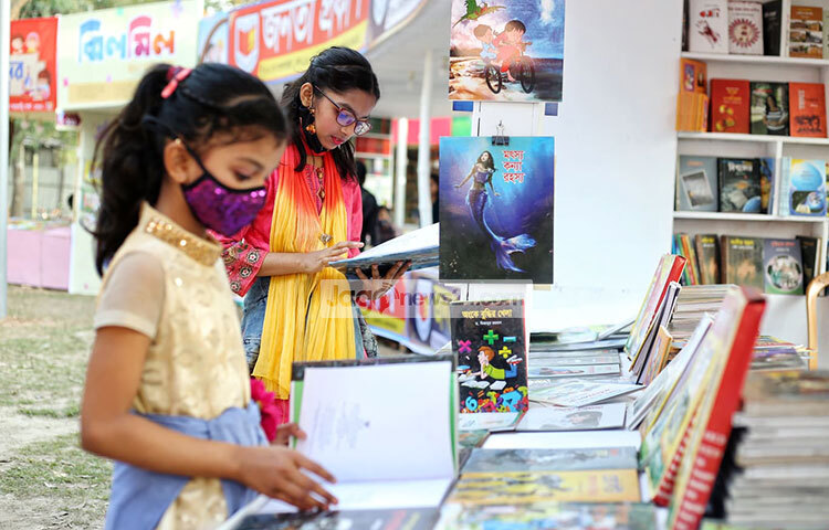 পছন্দের বই বাছাই করতে বই খুলে পড়ছে শিশুটি। ছবি: মাহবুব আলম