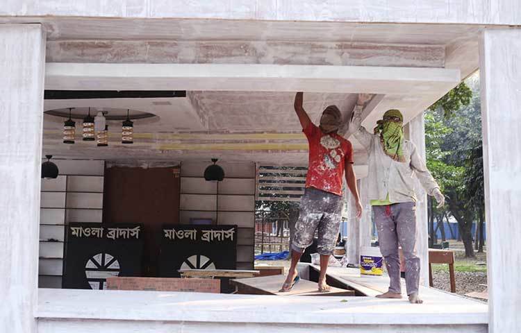 প্রকাশনা সংস্থা মওলা ব্রাদার্সের স্টলে রঙের কাজ চলছে। ছবি: মাহবুব আলম