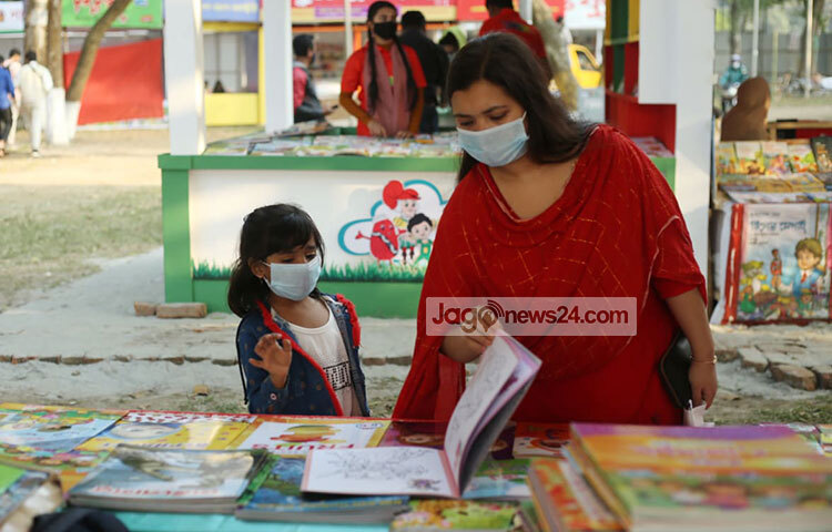 অভিভাবকের সঙ্গে স্টল ঘুরে ঘুরে বই দেখছে শিশুটি। ছবি: মাহবুব আলম