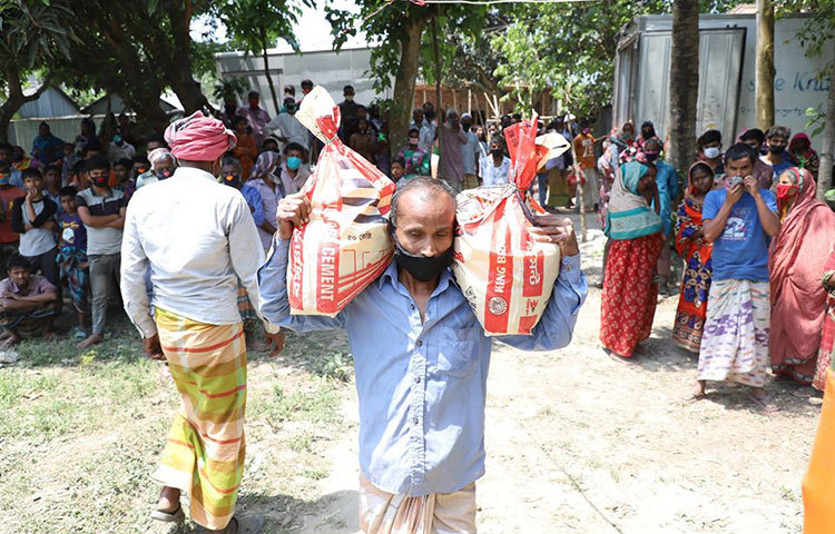 বর্ষার দেয়া ত্রাণ দিয়ে যাচ্ছেন একজন।