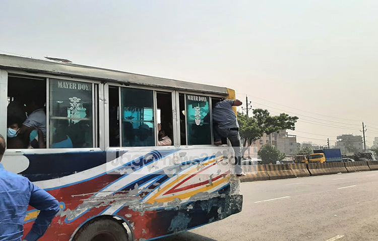বাসের দরজা দিয়ে উঠতে না পেরে এক যাত্রী জানালা দিয়ে উঠছেন। ছবি: মাসুদ রানা