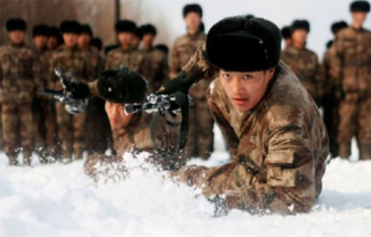 চীনের জিলিন প্রদেশের তাওনানের মিলিটারি বেসে বরফে ঢাকা প্রান্তরে পিএলএ-এর মেরিন কর্পস-এর দুই সদস্যের কসরত।