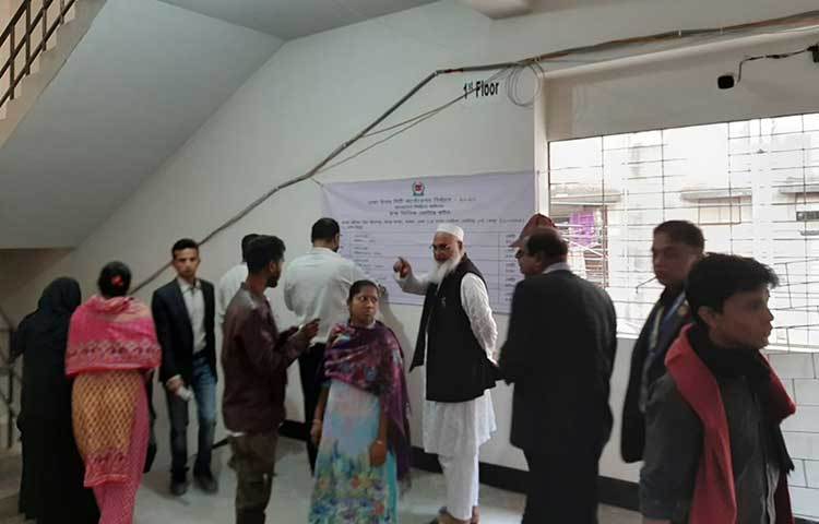 ভোট দেয়ার নির্দেশনা দেখছেন ভোটাররা। ছবি: জাগো নিউজ