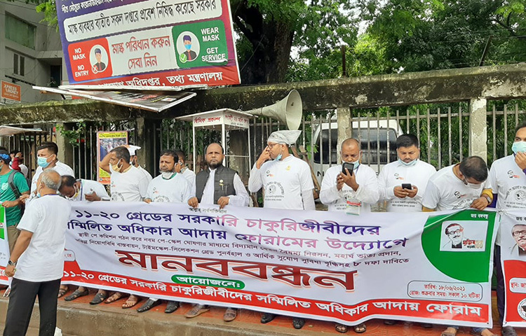 রাজধানীর জাতীয় প্রেস ক্লাবের সামনে এক মানববন্ধনে স্থায়ী পে কমিশন গঠন করে নবম পে-স্কেল ঘোষণার মাধ্যমে বেতনবৈষম্য নিরসনসহ  বিভিন্ন দাবি জানিয়েছে সম্মিলিত অধিকার আদায় ফোরাম। ছবি: জাগো নিউজ