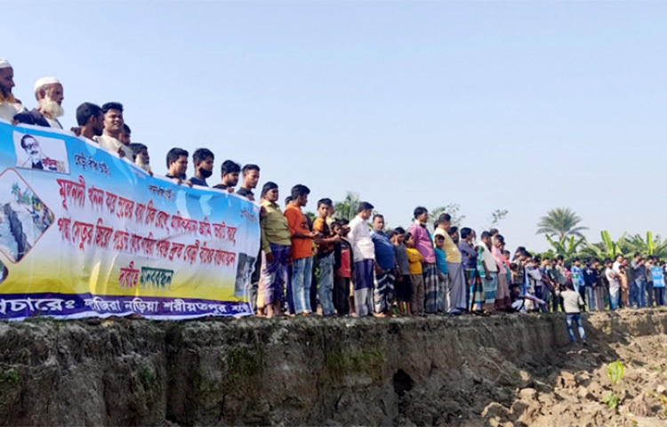 ‘ভাত চাই না, বাঁধ চাই; ত্রাণ চাই না, টেকসই বাঁধ চাই; আশ্বাস নয়, বাস্তবায়ন চাই; ভিটে-মাটি নিয়ে বাঁচতে চাই’ স্লোগানে ভারী হয়ে উঠেছে পদ্মা পাড়ের রঞ্জন ছৈয়ালেরকান্দি এলাকা। আজ শরীয়তপুরের জাজিরা উপজেলার বড়কান্দি ইউনিয়নের রঞ্জন ছৈয়ালেরকান্দিতে স্থায়ী ও টেকসই বেড়িবাঁধ নির্মাণের দাবিতে মানববন্ধন ভাঙনকবলিত মানুষ। ছবি: মো. ছগির হোসেন