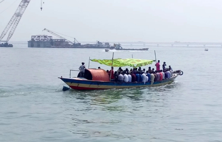 শিমুলিয়ায় সরেজমিনে দেখা যায়, পদ্মার শিমুলিয়া-বাংলাবাজার নৌ-রুটে লঞ্চ ও স্পিডবোট বন্ধ থাকায় যাত্রীরা ফেরিযোগে নদী পারাপার করছেন। ঝুঁকি নিয়ে অনেক যাত্রী ট্রলারযোগে পদ্মা পাড়ি দিচ্ছেন। ছবি: জাগো নিউজ