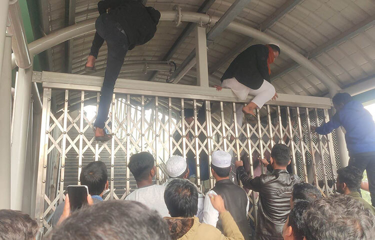 দুপুর ১২টা বাজার আগেই বন্ধ করে দেওয়া হয় মেট্রোরেলে প্রবেশের মূল গেট। এতে ক্ষুব্ধ হয়ে পড়েন বাইরে অপেক্ষায় থাকা যাত্রীরা। সকাল থেকে অপেক্ষার পর মেট্রোরেলে চড়তে না পারায় ক্ষোভ প্রকাশ করেন তারা। এসময় মূল গেটে ধাক্কাধাক্কি করেন অনেকেই। কেউ কেউ আবার গেট টপকে স্টেশনের ভেতরে ঢোকার চেষ্টা করেন। পরে পুলিশ এসে পরিস্থিতি নিয়ন্ত্রণে আনে। ছবি: মাহববু আলম