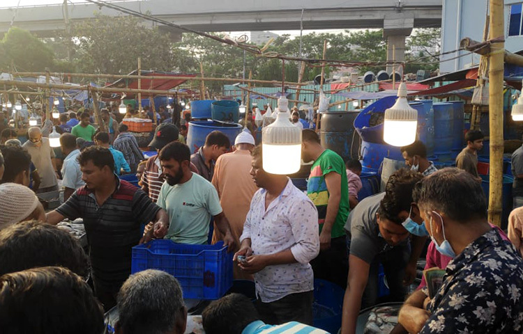 রাজধানীর কারওয়ানবাজারে স্বাস্থ্যবিধি কেউ মানছেন না। ভোর থেকে হাজারো ক্রেতা-বিক্রেতার উপস্থিতিতে বাজার জমজমাট থাকলেও মাস্ক পরা বা সামাজিক দূরত্ব বজায় রাখার বিষয়টি এখানে ভীষণভাবে উপেক্ষিত। ছবি: জাগো নিউজ