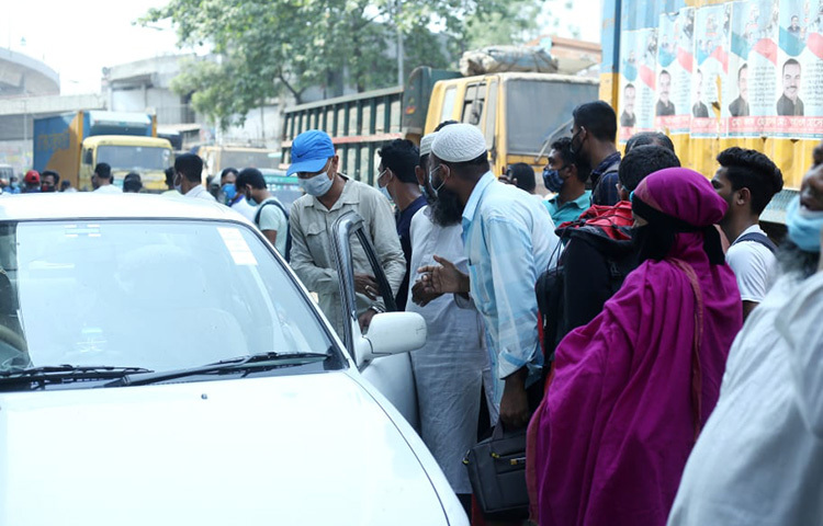 লকডাউনের কারণে ঢাকার যাত্রাবাড়ীতে ঘরমুখো মানুষের ভিড় বাড়ছে। দূরপাল্লার বাস চলাচল বন্ধ থাকায় বেশিরভাগ যাত্রী প্রাইভেটকার, সিএনজি, পিকআপভ্যান এবং ট্রাকে করে যাতায়াত করছেন। ছবি: জাগো নিউজ