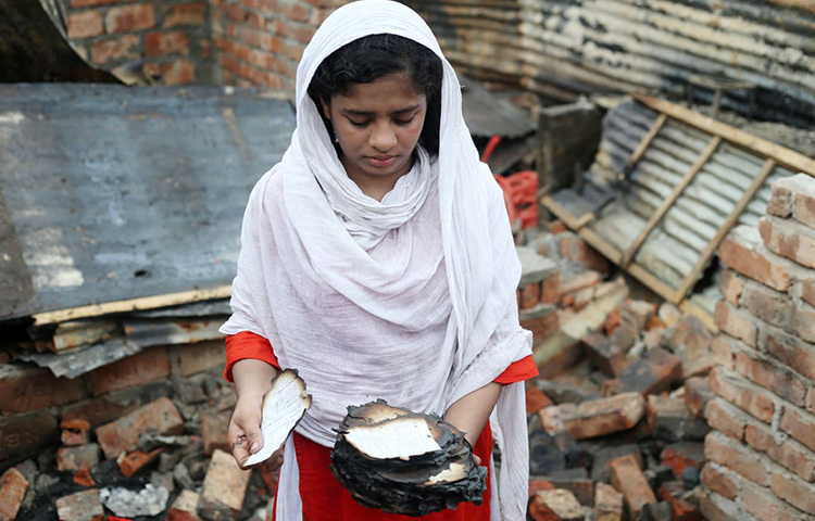 আজ ভোররাতে বাজধানীর মহাখালীর সাততলা বস্তিতে অগ্নিকাণ্ডের ঘটনা ঘটেছে। আগুনে পুড়েছে এই কিশোরীর পাঠ্যবই। বই পোড়া দৃশ্য দেখে ভীষণ মন খারাপ তার। ছবি: মাহবুব আলম