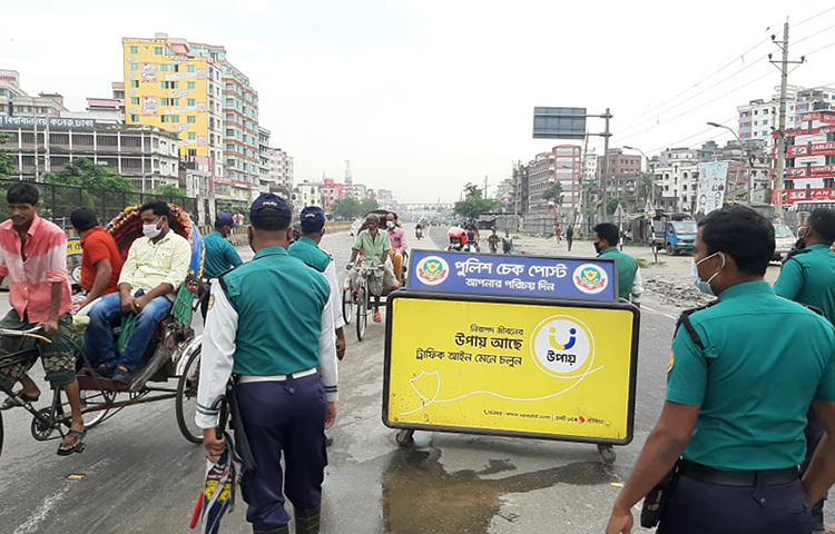 কঠোর লকডাউনের প্রথমদিনে রাজধানীর সড়কগুলোতে স্বাস্থ্যবিধি মেনে মানুষকে চলাচলের জন্য সতর্ক করেছে পুলিশ। ছবি: বিপ্লব দিক্ষিৎ