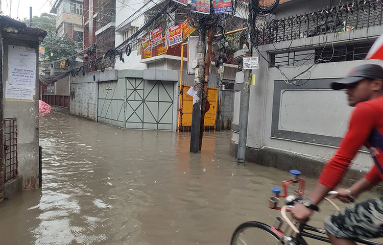 গতরাত থেকে টানা বৃষ্টিতে রাজধানীর অনেক এলাকার রাস্তা পানিতে ডুবে গেছে। ছবি: মাহবুব আলম