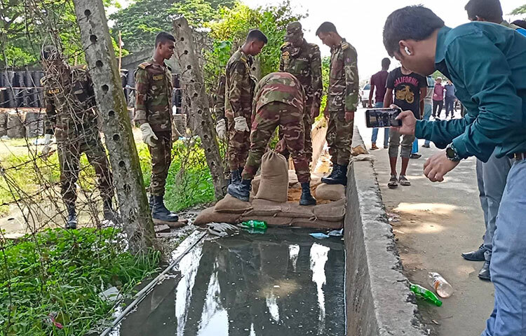 চট্টগ্রামের সীতাকুণ্ডে বিএম কনটেইনার ডিপোতে বিস্ফোরণে কেমিক্যাল ছড়িয়ে পড়া রোধে প্রয়োজনীয় ব্যবস্থা নিয়েছে বাংলাদেশ সেনাবাহিনী। এরই মধ্যে বালুর বস্তা দিয়ে ড্রেনেজব্যবস্থা বন্ধ করে দিয়েছে বাংলাদেশ সেনাবাহিনীর একটি বিশেষ ইঞ্জিনিয়ারিং টিম। ছবি: জাগো নিউজ